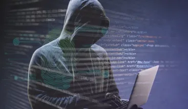 Hacker de casaco digitando em um notebook