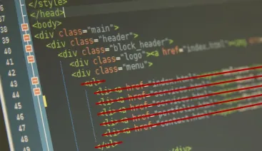 Editor HTML na tela de um computador com algumas linhas de código riscadas em vermelho