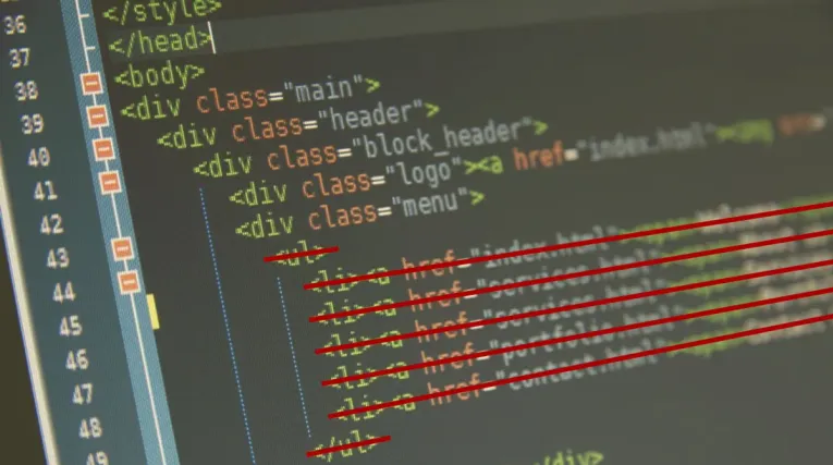 Imagem princial: Editor HTML na tela de um computador com algumas linhas de código riscadas em vermelho